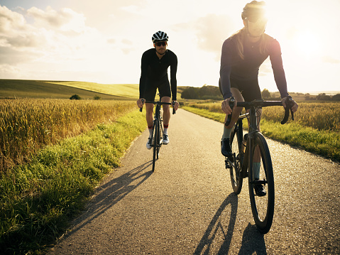 Shot of two cyclists out cycling on a country road