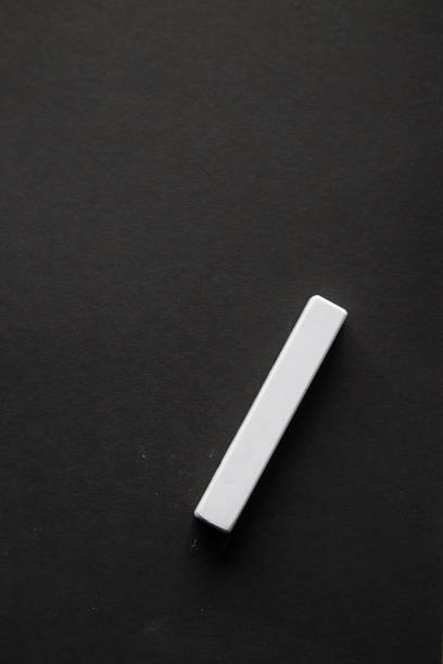 istock One piece of white chalk on black coated paper 1165508566