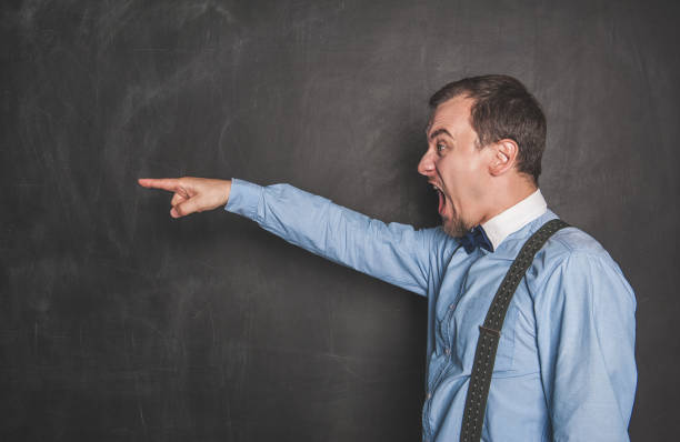 homme criant fâché d'enseignant se dirigeant sur le tableau noir - desk men bizarre classroom photos et images de collection