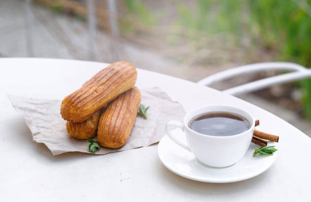 Fragrant coffee with eclairs in the summer cafe.