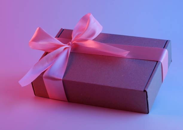 istock Gift box with pink ribbon in neon light 1165514613