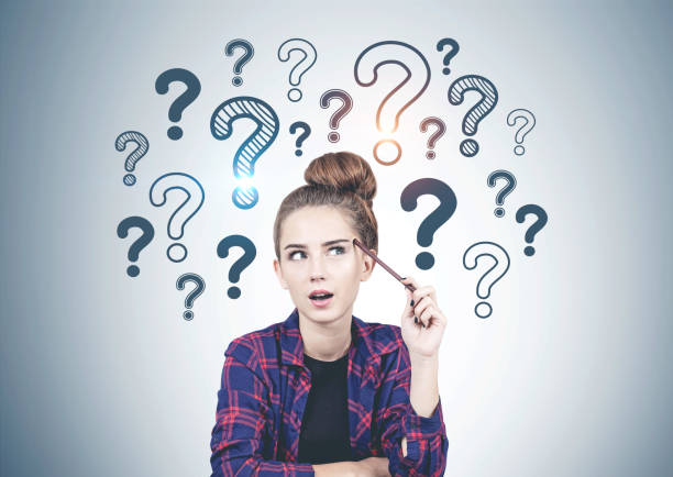istock Thinking teen girl question marks on grey wall 1165514862