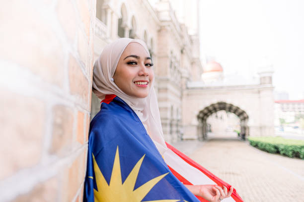 istock Young Woman Looking at Camera with Malaysia Flag 1165515467