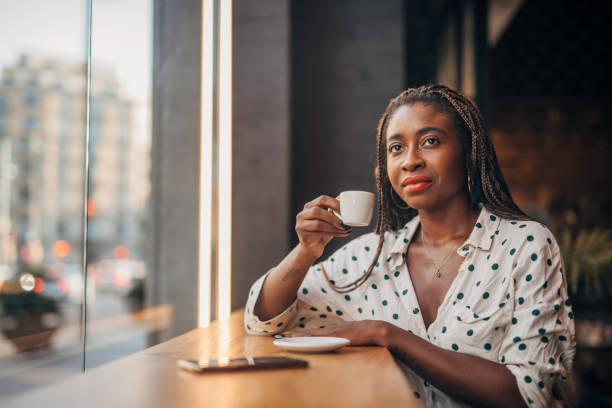 istock Black woman drinking coffee in cafe 1165516579