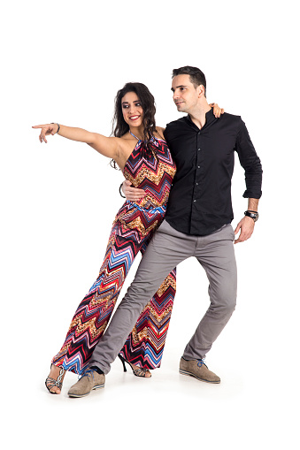 Young couple dancing salsa, isolated on white background. About 25 years old woman, Latin brunette with curly hair and about 30 years old Caucasian man.