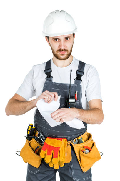 istock A builder or worker in a protective helmet breaks the contract that he holds in front of him. Isolated on white background 1165517943