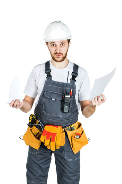 istock A builder or worker in a protective helmet breaks the contract that he holds in front of him. Isolated on white background 1165518091