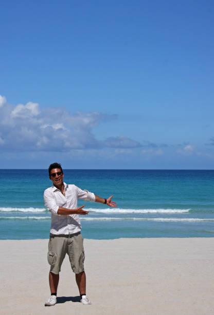 istock Young man pointing at copy space area at the beach 1165518243