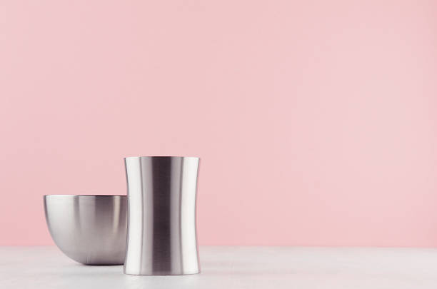 istock Simplicity elegant home decor with silver elegant glossy bowl and vase on white wood board and soft light pink background. 1165519287