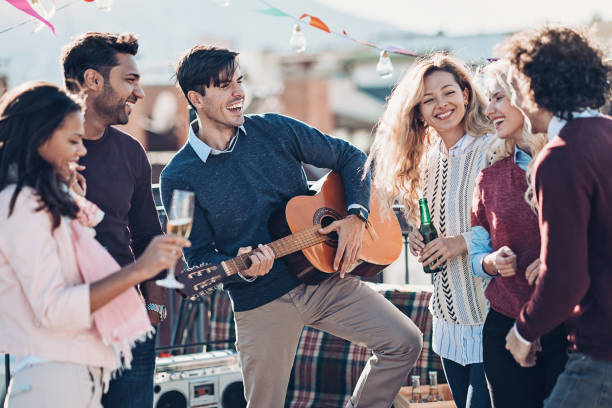 istock Friends playing guitar and drinking on a party 1165519478