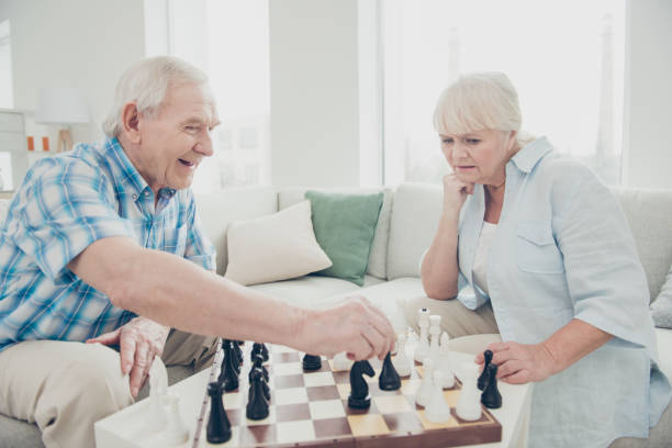 istock Profile side view portrait of her she his he two nice attractive bewildered concentrated focused people playing chess creating move strategy win winner in light white interior living-room house 1165519770