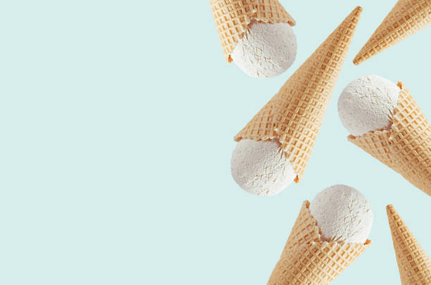 istock White creamy ice cream in waffle cones as decorative border on light  green background, mock up, copy space. 1165521264