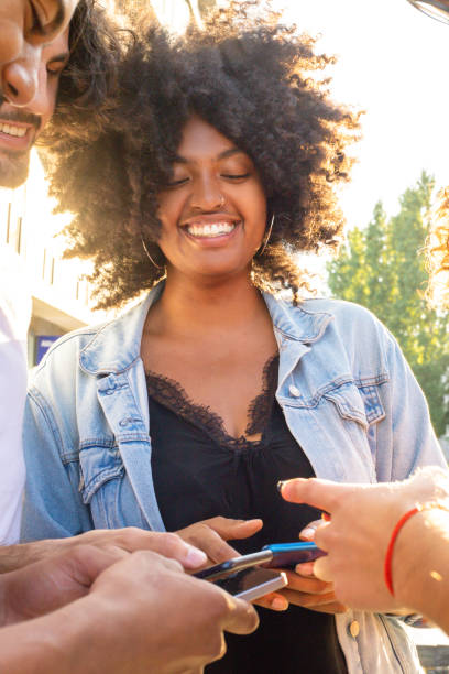 istock Happy cheerful African American woman sharing phone data 1165523110