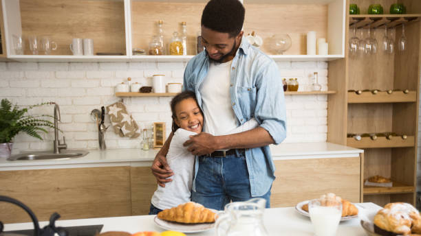 istock Grateful afro girl hugging her father before breakfast 1165524892
