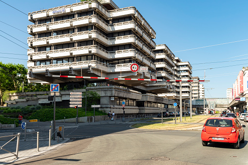 Modern apartments in Bordeaux in the Meriadeck area. The building on the left appears to have various layers overhanging and on the right is a 1960s concrete structure that is beginning to look dirty with drainage marks on its surface.