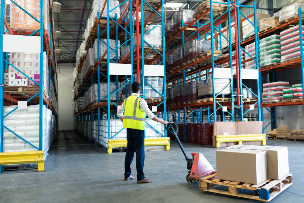 istock Male staff using pallet jack in warehouse 1165528179
