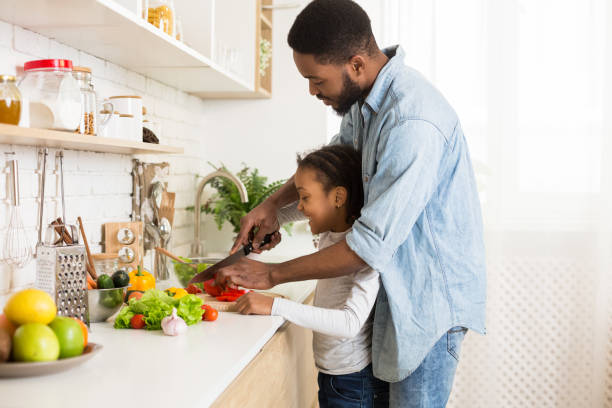 istock Dad teaching daughter how to make salad 1165528226