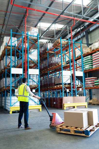 istock Male staff using pallet jack in warehouse 1165528231