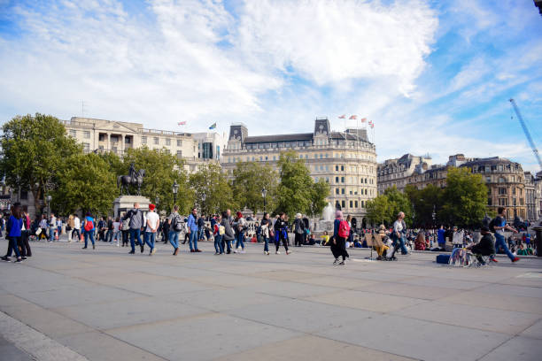 turisti in giro per trafalgar square a westminster, londra, inghilterra - il monumento di nelson foto e immagini stock