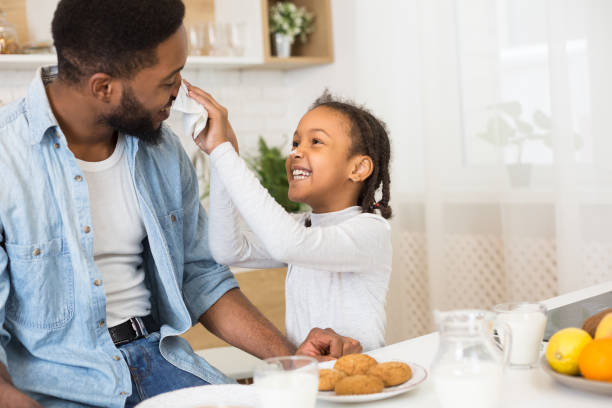 istock Father and daughter having fun and eating cookies 1165529255