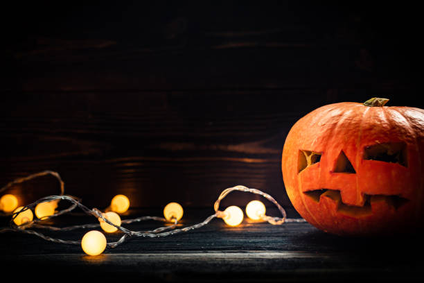 istock Halloween Night Pumpkin dark wooden background 1165529284