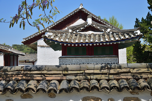 Roof of the Korean traditional house or Hanok in Kaesong. North Korea. Focus on the stone fence
