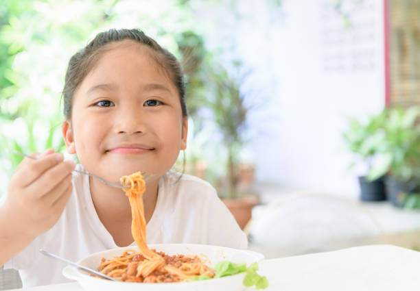 istock Girl enjoy eating spaghetti with pork sauce 1165534548