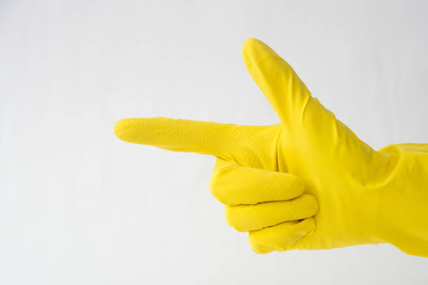 istock hand in yellow glove, finger gesture forward, direction indication 1165536484