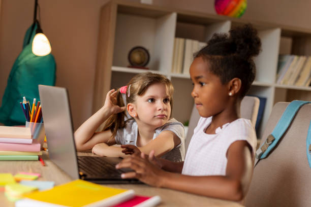 istock Little girls doing homework on a laptop computer 1165537023