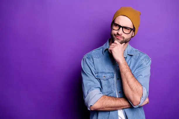 Photo of Portrait of his he nice attractive doubtful bearded guy touching chin thinking guessing strategy copy space isolated over bright vivid shine violet lilac purple background