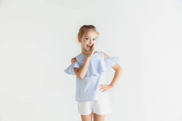 istock Little smiling girl posing in casual clothes on white studio background 1165540741