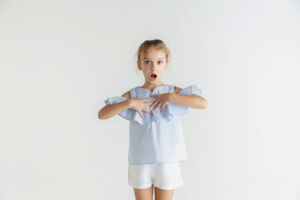 istock Little smiling girl posing in casual clothes on white studio background 1165540745