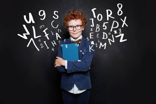 istock School boy in blue student uniform with book on blackboard background 1165543752
