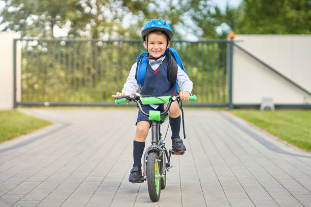 istock School boy in safety helmet riding bike with backpack 1165549872