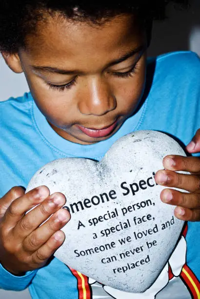 Photo of Boy holding a heart shaped stone in memory of 