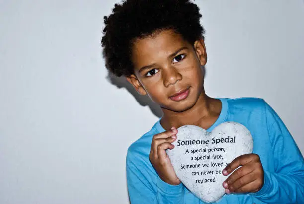 Photo of Boy holding a heart shaped stone in memory of 