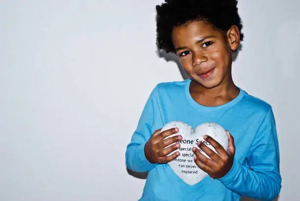 Photo of Boy holding a heart shaped stone in memory of 