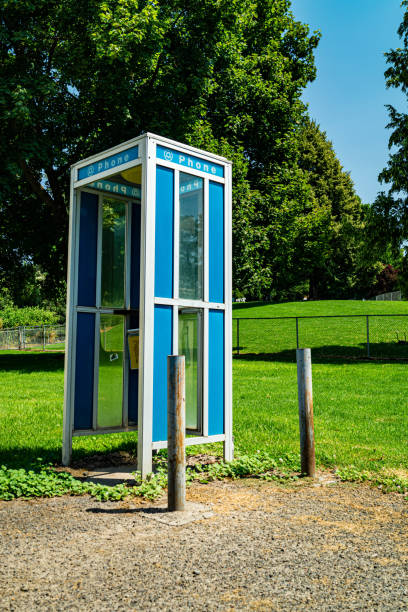 istock Vintage telephone booth near a public park 1165557745
