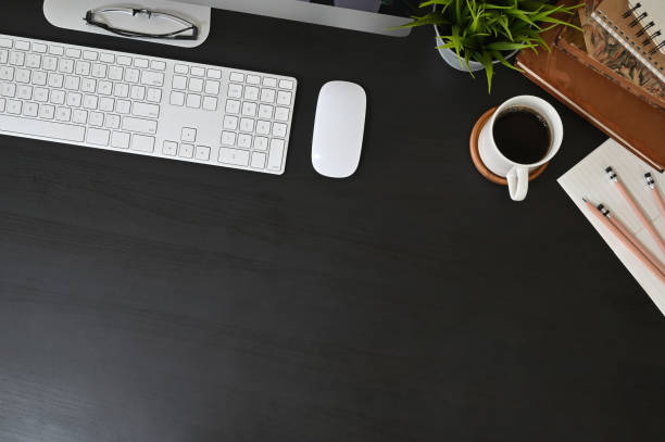 istock Office desk computer and office supplies with coffee on black table. 1165558402