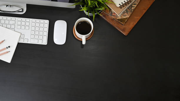 istock Office desk computer and office supplies with coffee on black table. 1165558414