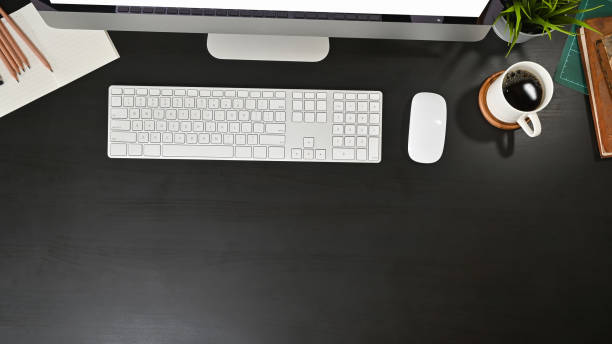 istock Office desk computer and office supplies with coffee on black table. 1165558424