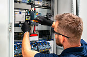 Electrician working at electric panel