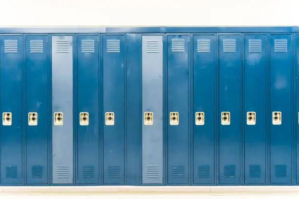 Worn down navy blue school lockers straight on