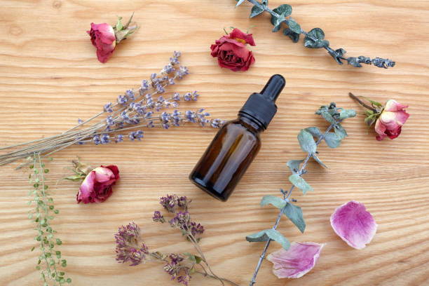 istock Essential oil with herbs and flowers on wooden table 1165563973