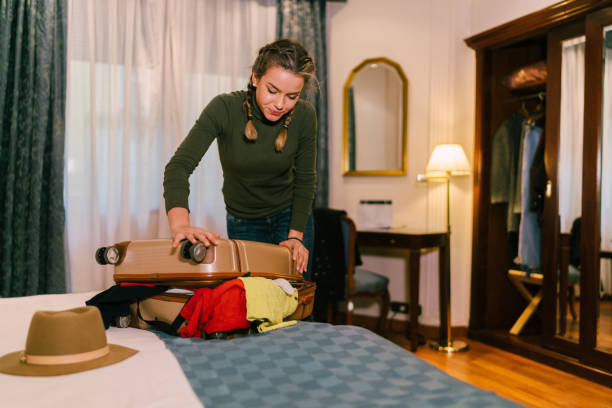 istock Girl closing suitcase in hotel room 1165564026