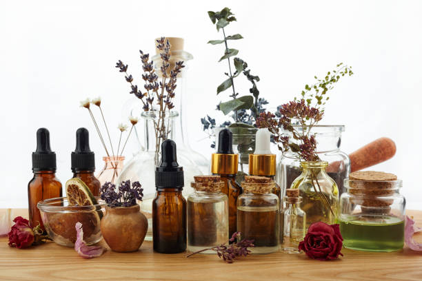 istock Essential oils with herbs and flowers on wooden table 1165564666
