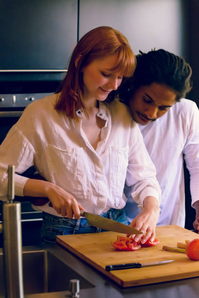 istock Black man and Caucasian redhead woman preparing vegetables 1165565108