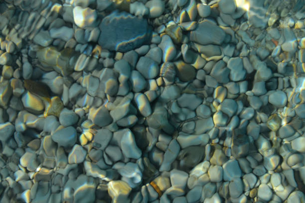 beautiful colorful pebbles and big stone under turquoise blue clear water, scenic marine background or texture, top view - ocean scenic flash imagens e fotografias de stock
