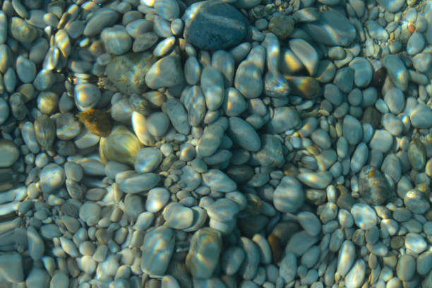 beautiful colorful pebbles and big stone under turquoise blue clear water, scenic marine background or texture, top view - ocean scenic flash imagens e fotografias de stock