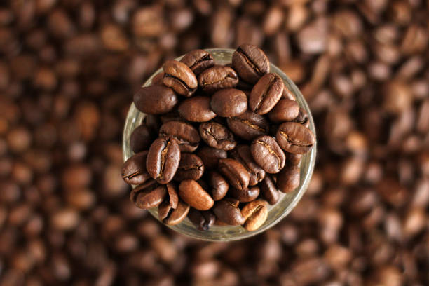 istock Coffee beans in the orange bowl. Top view. Isolated on white background. 1165568326